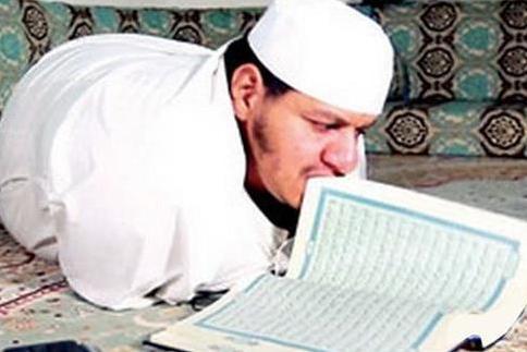 الشاب الذی یتصفح القرآن بأسنانه 